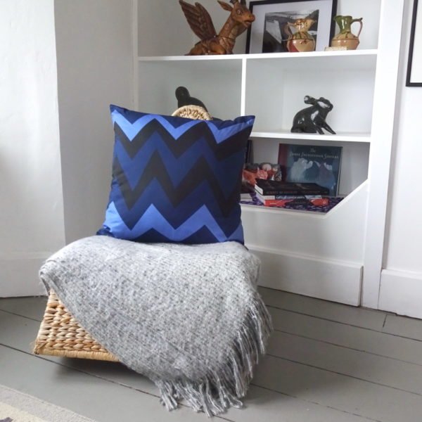 Madam X back of cushion with zigzag pattern done in blues. In situ on rocking chair. wicked imp designs